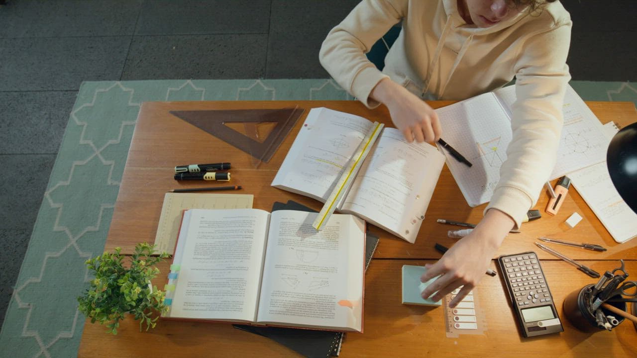 A desk of open books and notes, mid-study