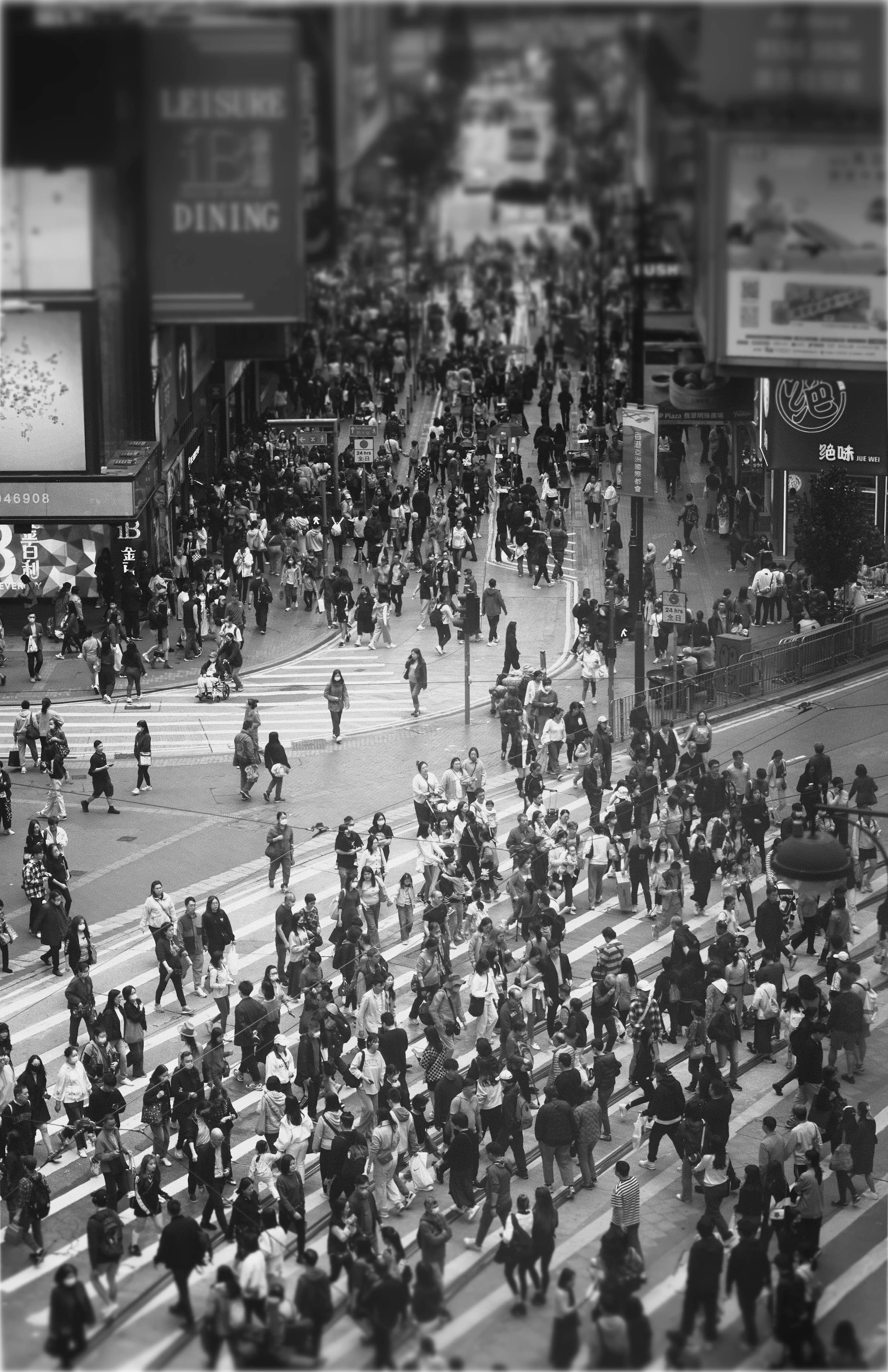 A dense crowd crossing a wide city intersection, seen from above