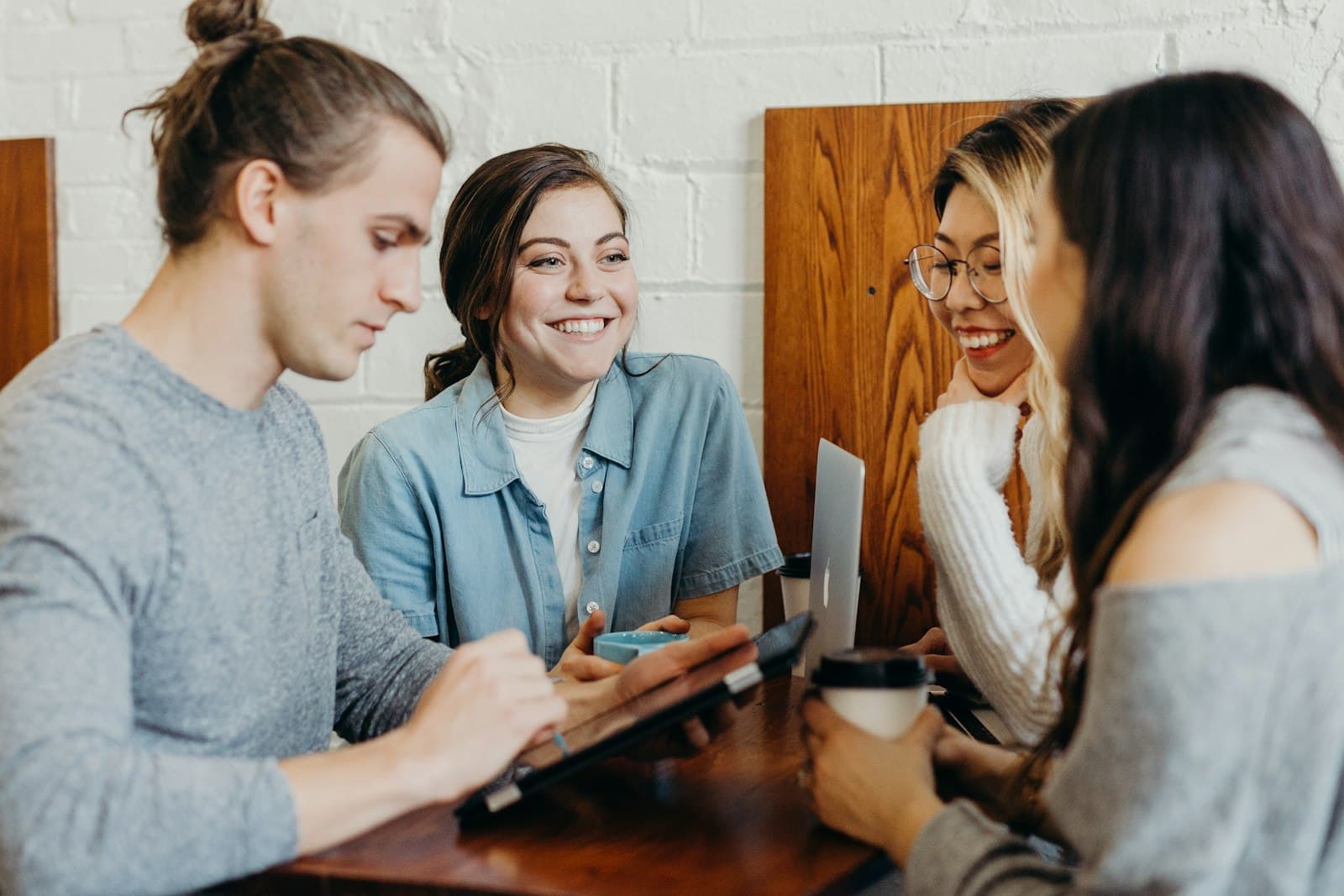 Four people talking and laughing around a table