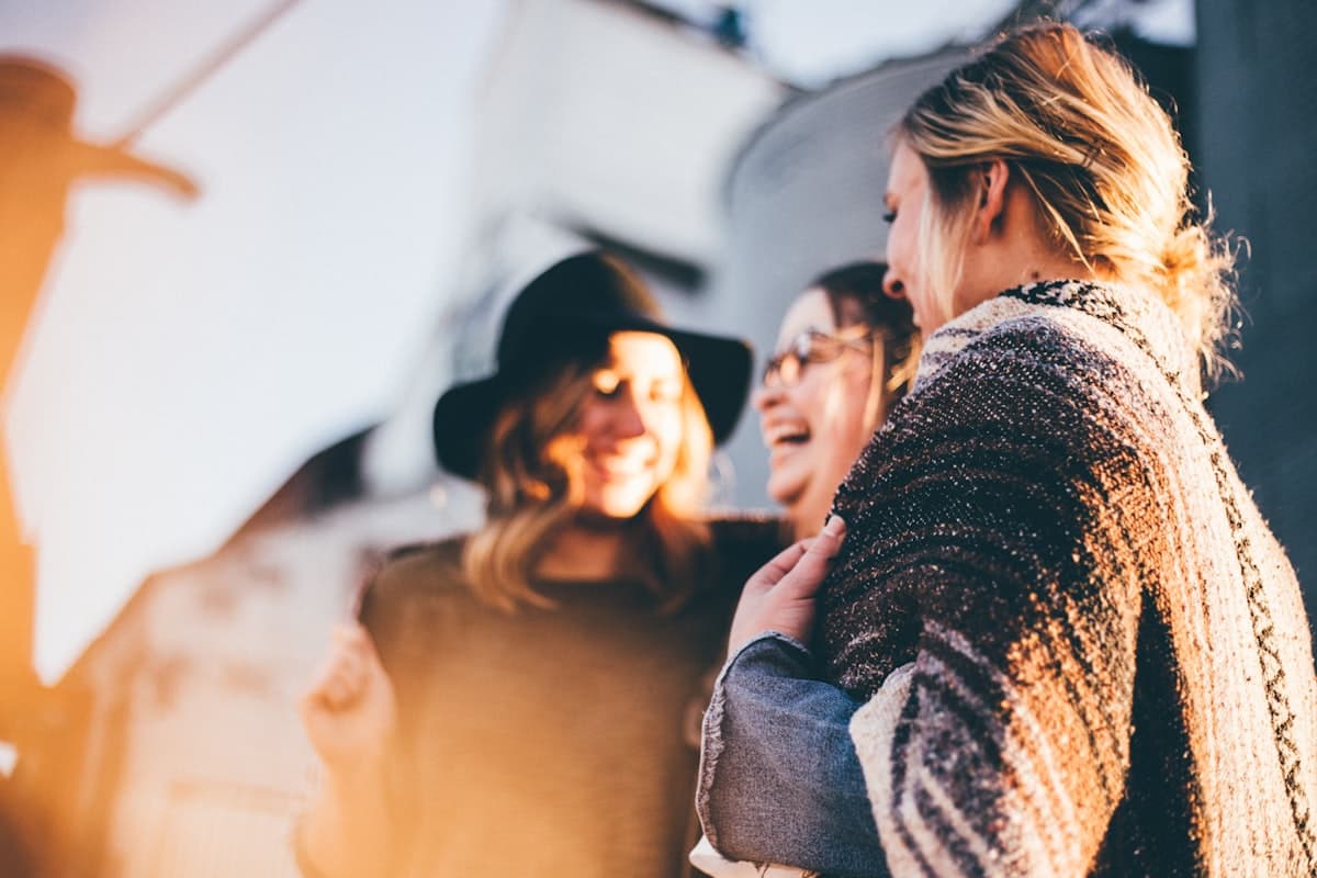 Two women laughing together in golden evening light