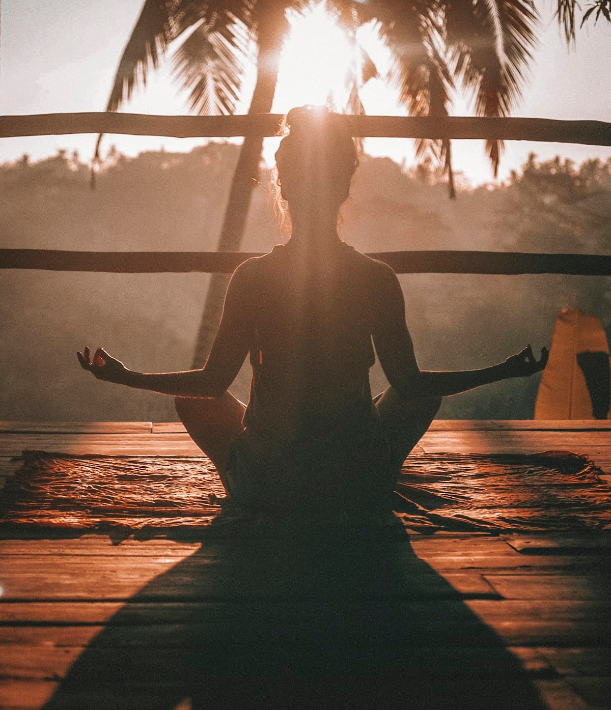 A person meditating alone by a sunlit window